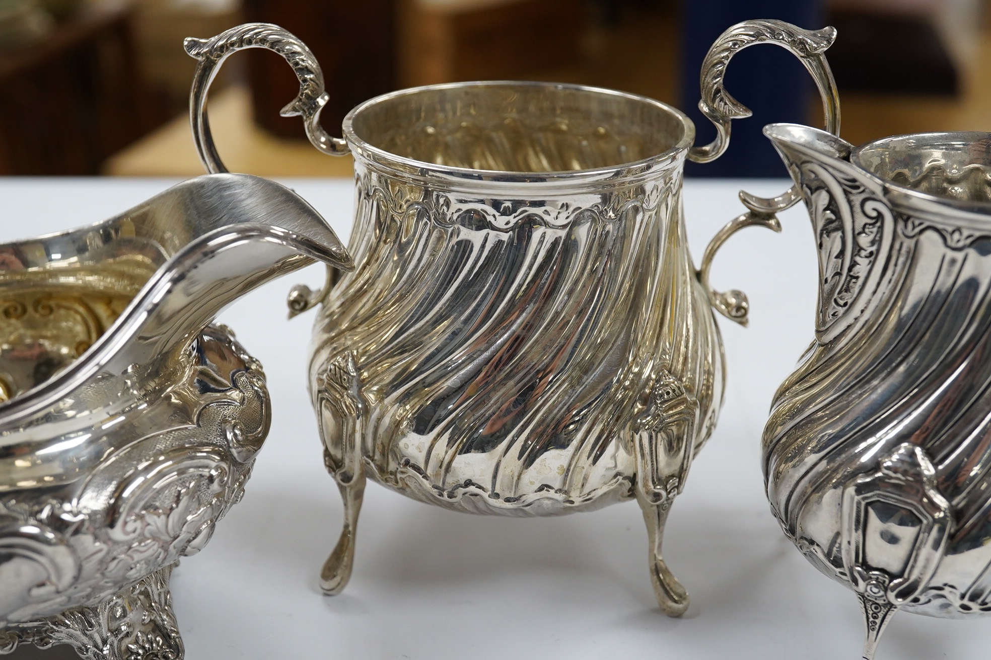 A late Victorian silver cream jug and sugar bowl, by Mappin & Webb, London, 1900 and an earlier William IV silver cream jug, London, 1835, 16.1oz. Condition - fair to good